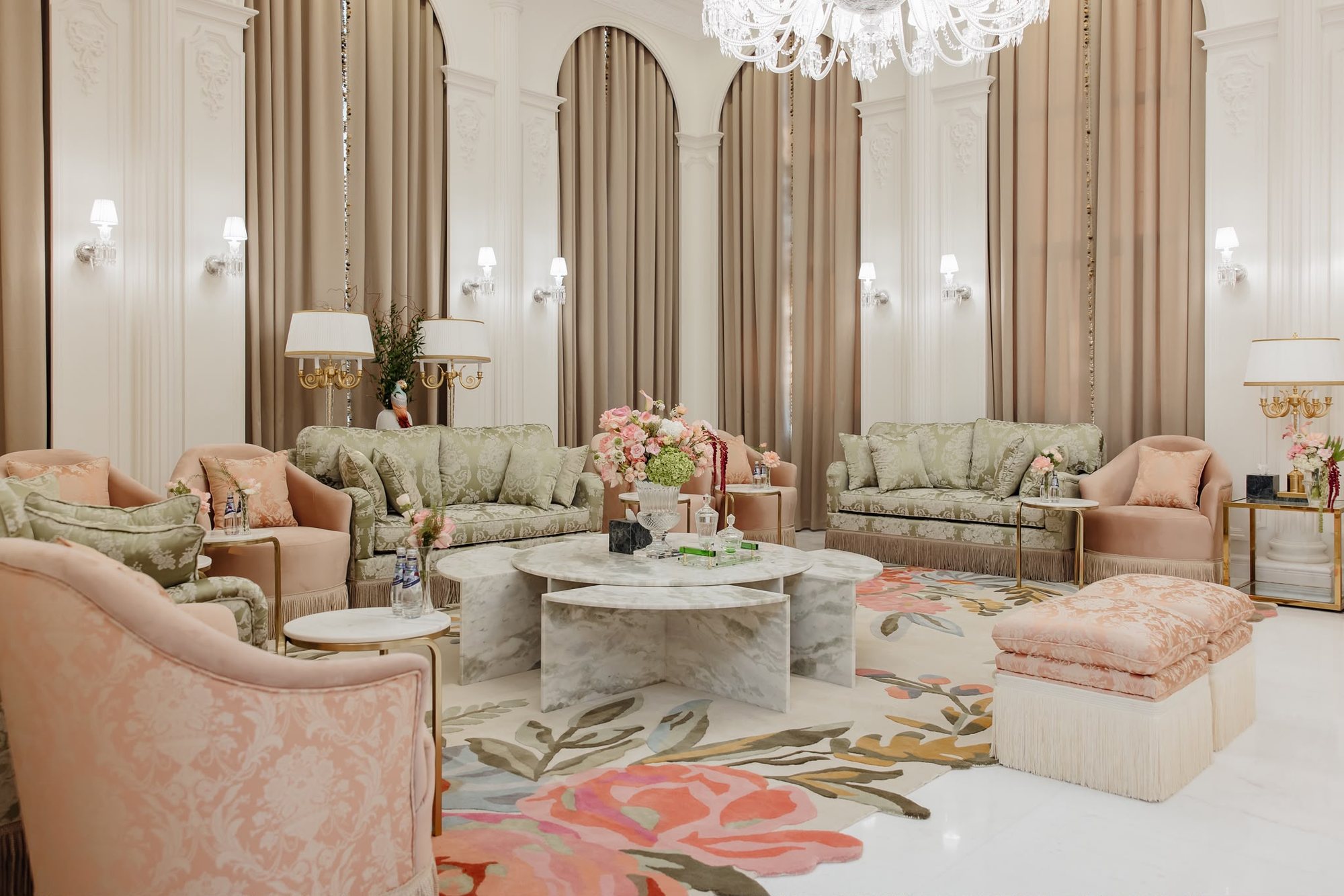 Real project sitting room with sage upholstery, blush seating, floral rug, marble table, and warm curtains