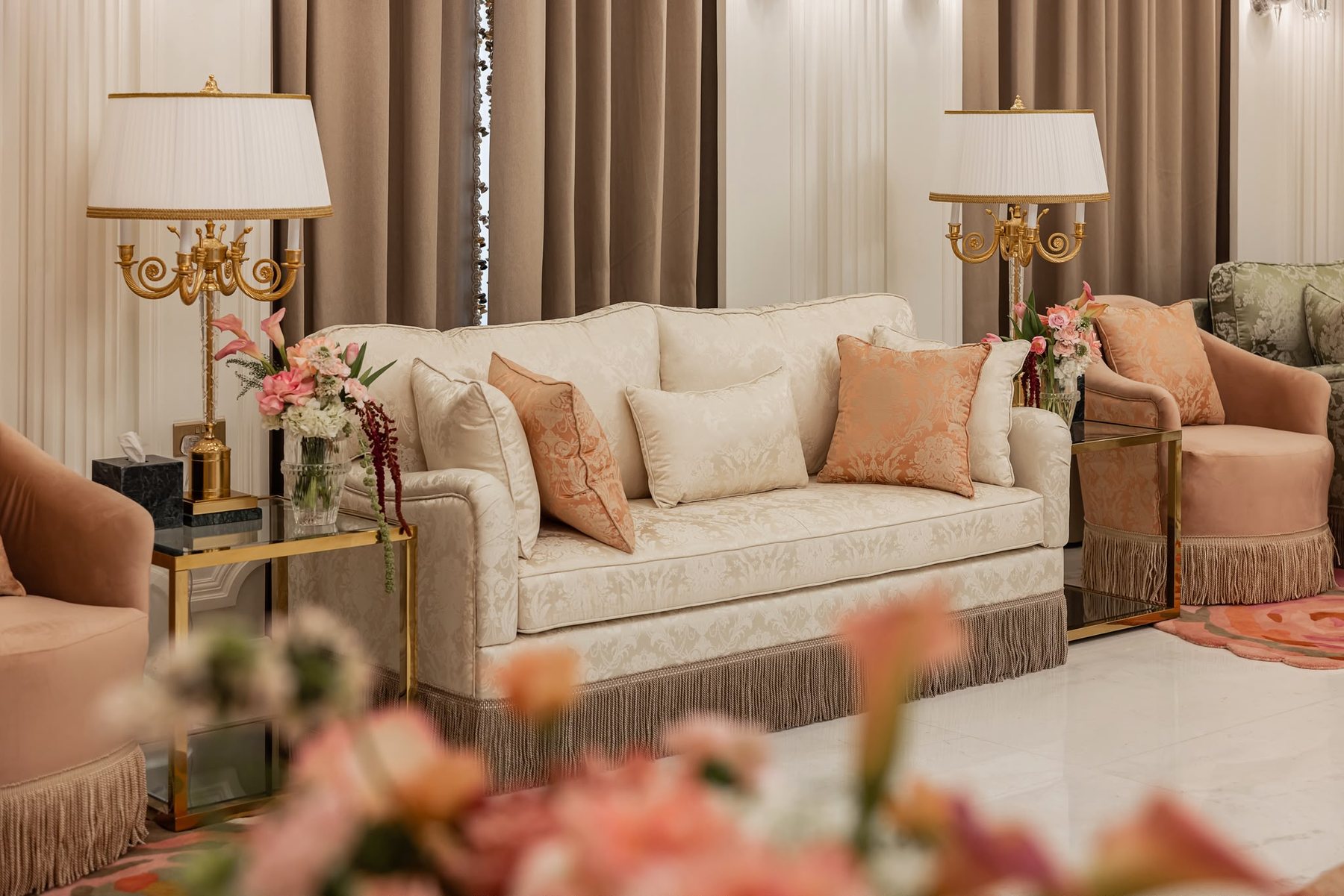 Real project sofa angle with cream sofa, blush cushions, side lamps, curtains, and soft foreground styling